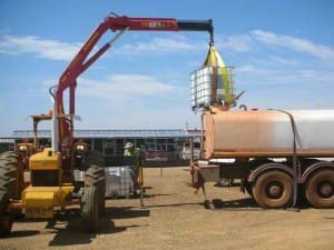 Using a crane to lift EBS into position for loading into water tanker